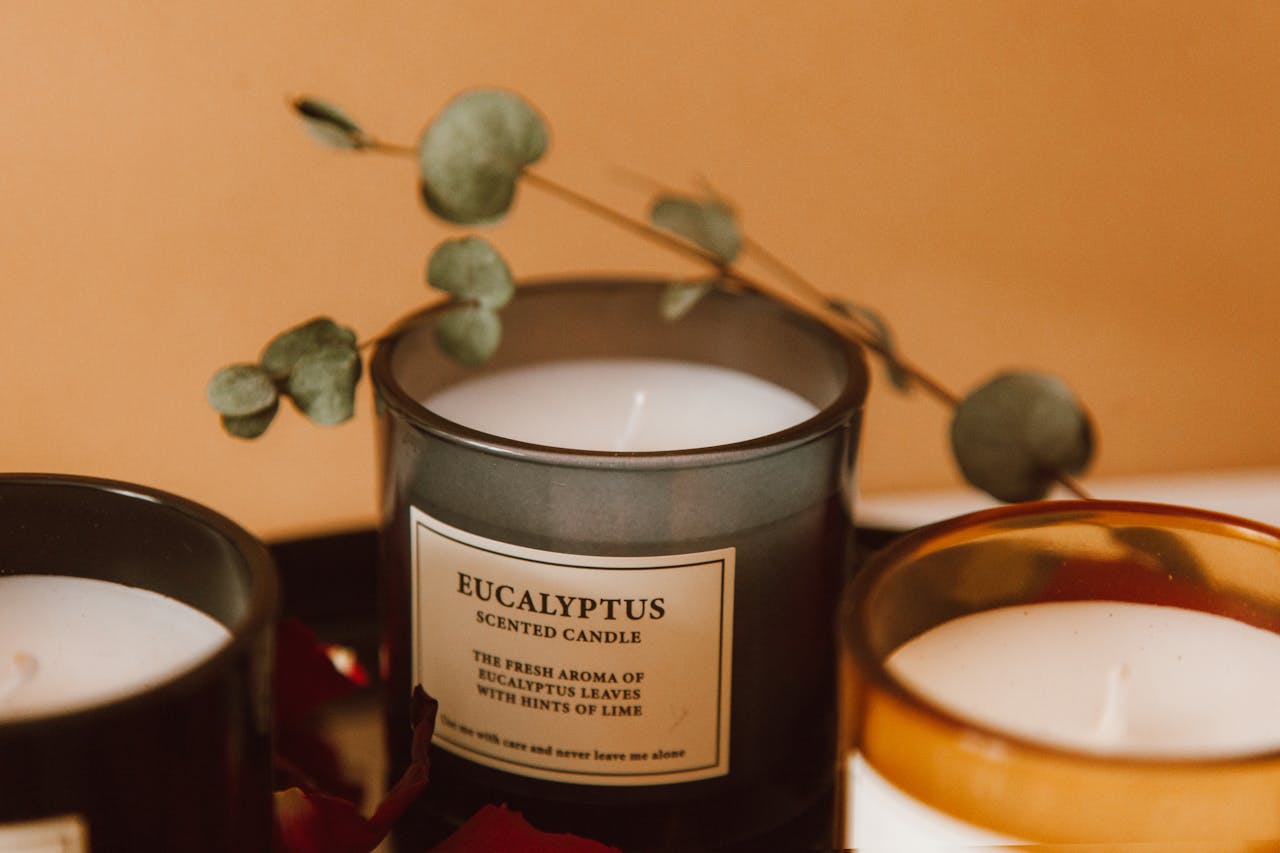 Close-up of eucalyptus scented candles with dried eucalyptus leaves, creating a warm aromatic ambiance.