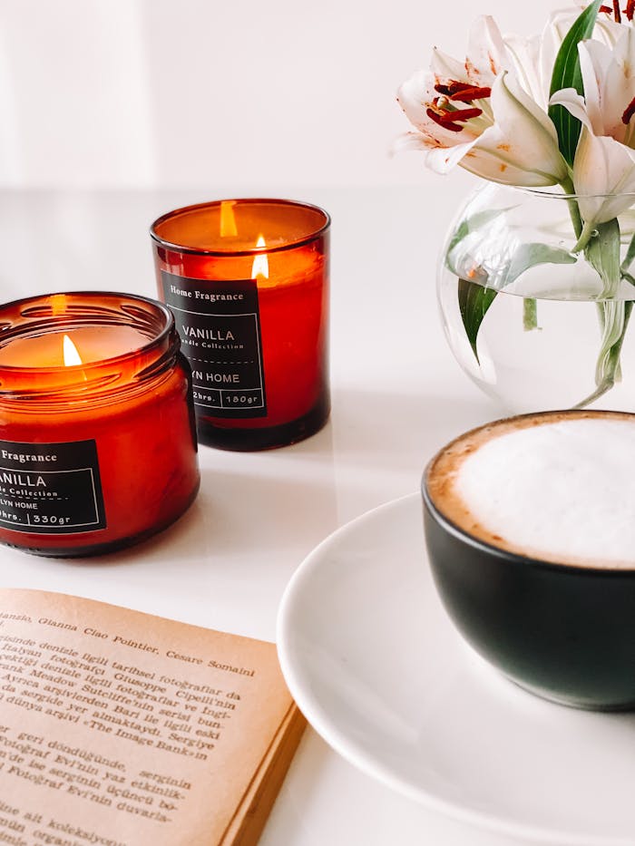 Warm ambiance with coffee, candles, and flowers for a relaxing moment.